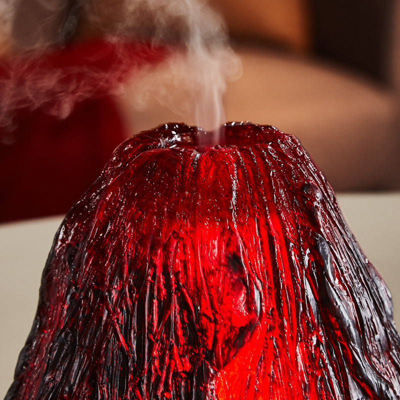 Red and black lava-like sculpture with steam rising from it on a blurred background