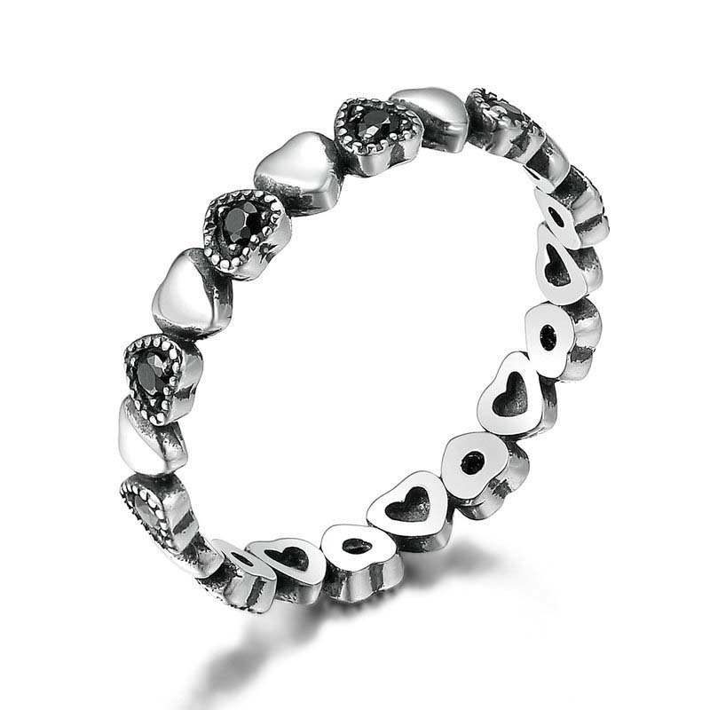 Silver ring with heart-shaped designs on a white background
