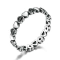 Silver ring with heart-shaped designs on a white background