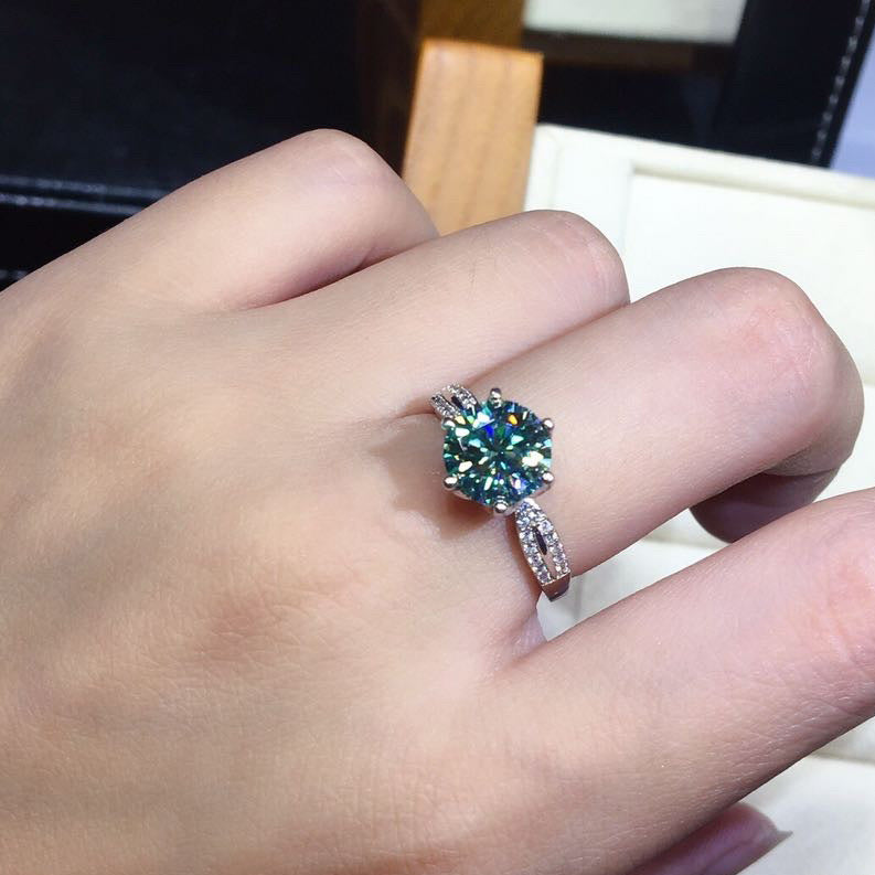 Close-up of a hand wearing a ring with a large green gemstone.