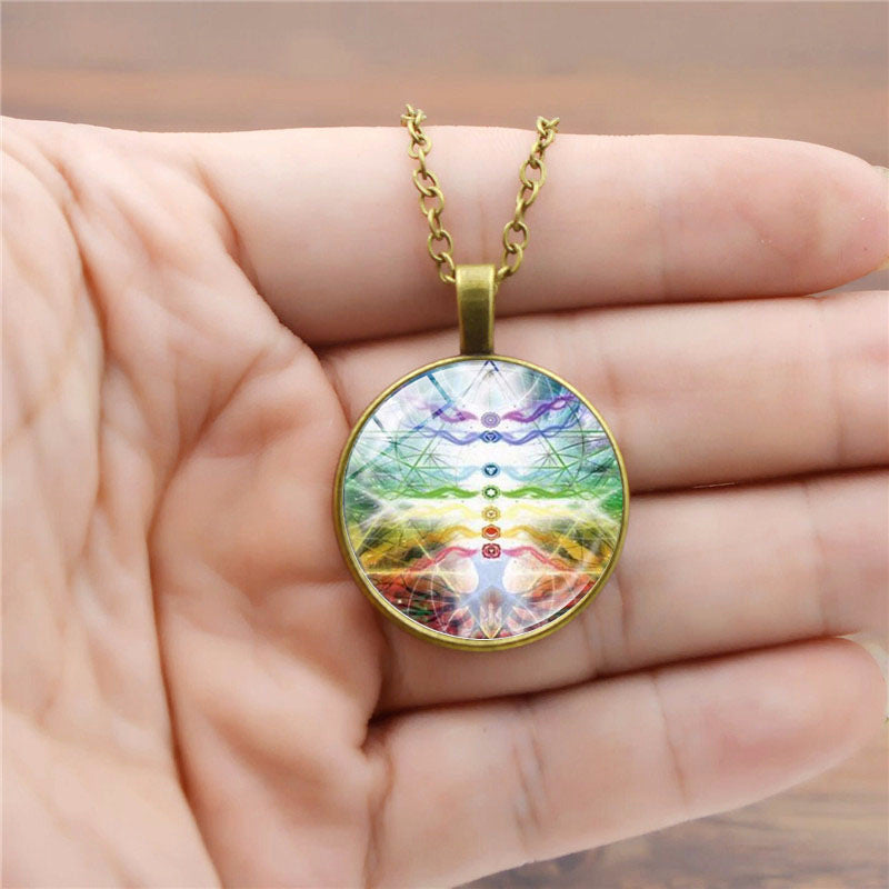 Colorful pendant with gold chain held in a hand
