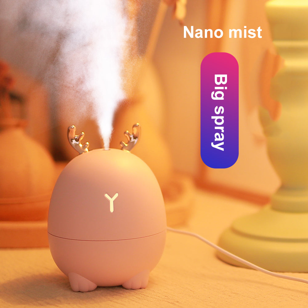 Small humidifier with reindeer antlers emitting mist on a blurred background