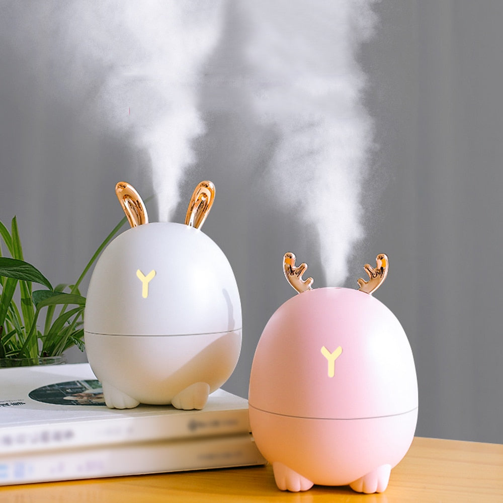Two cute humidifiers with animal ears on a wooden surface.