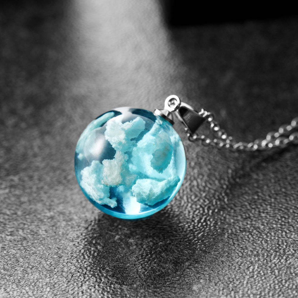 Necklace with a blue glass pendant on a textured surface