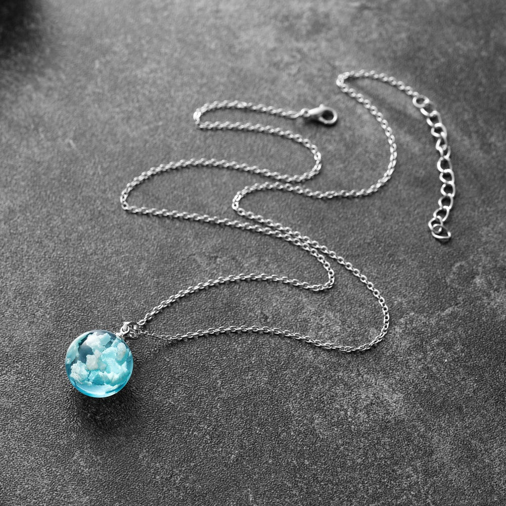Necklace with a blue pendant on a dark surface
