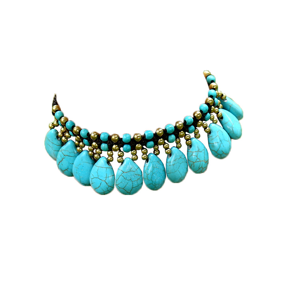 Turquoise teardrop necklace with gold accents on a white background