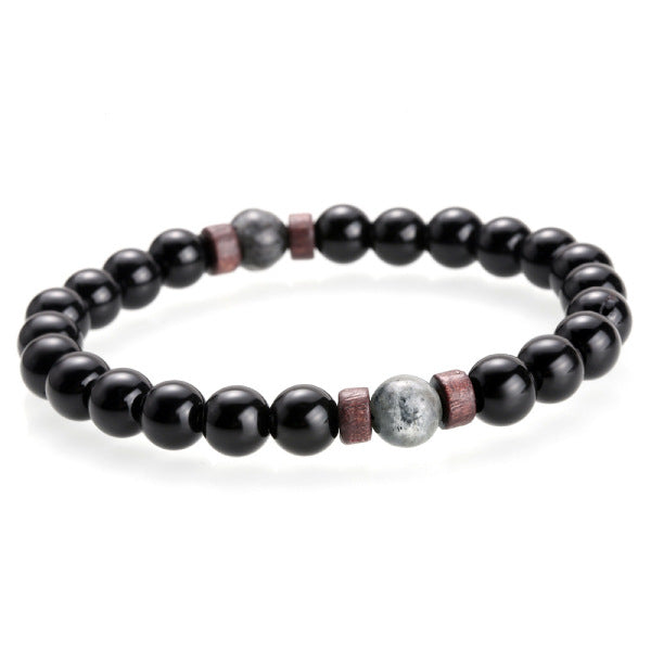 Black beaded bracelet with a few larger beads on a white background