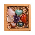 Box of heart-shaped colorful stones on a white background