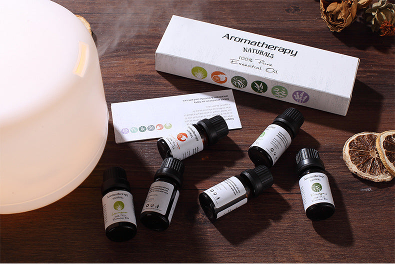 Aromatherapy oils and diffuser on a wooden surface