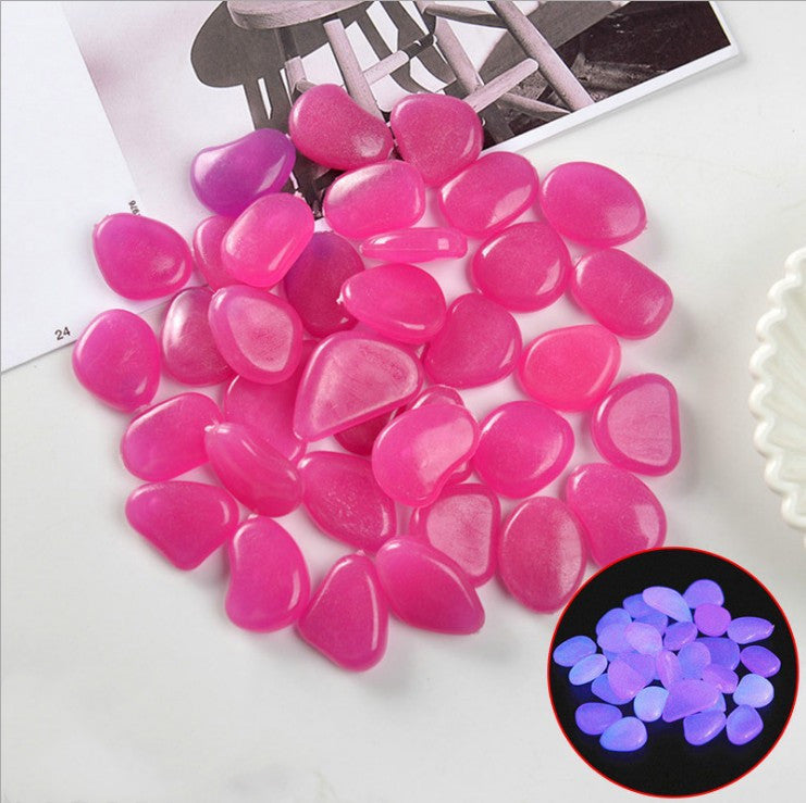 Pink heart-shaped stones on a white surface with a close-up inset showing their glow-in-the-dark property.