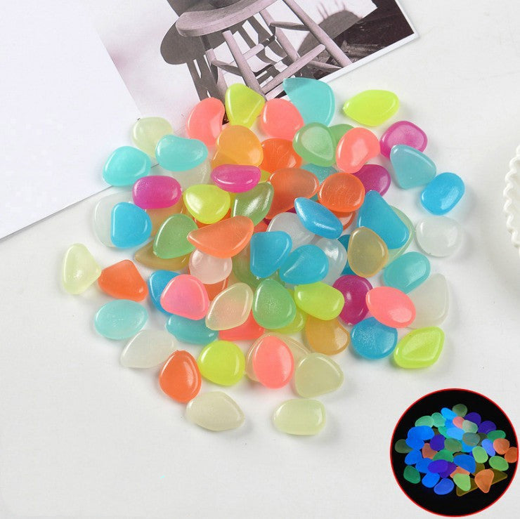 Colorful glowing stones on a white surface with a close-up inset showing their glow.