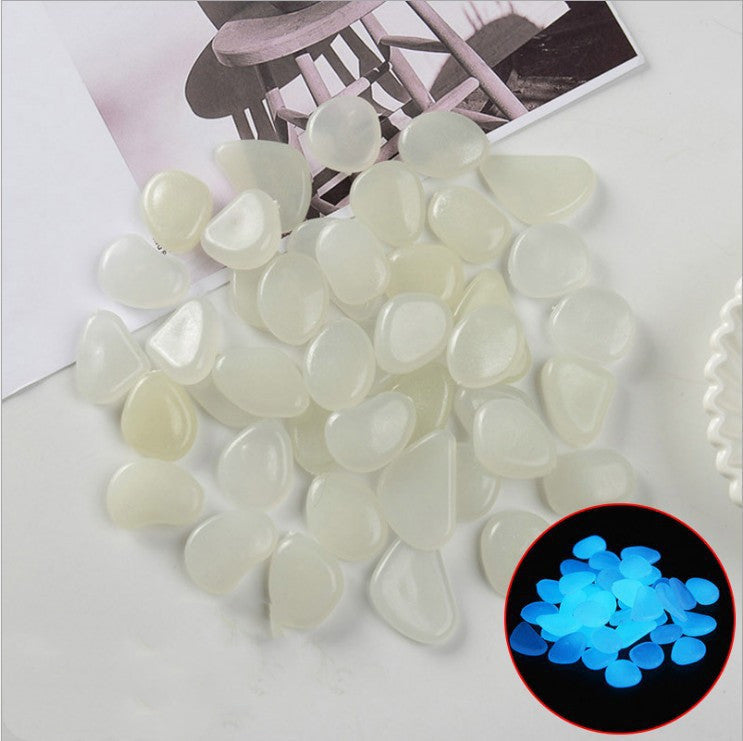 Glowing pebbles on a white surface with an inset showing their glowing effect.