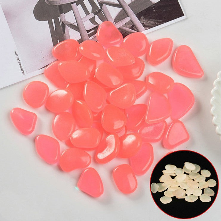 Pink heart-shaped stones on a white surface with a black and white photo in the background.