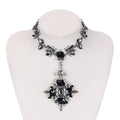 Necklace with black and silver pendant on a mannequin bust against a white background