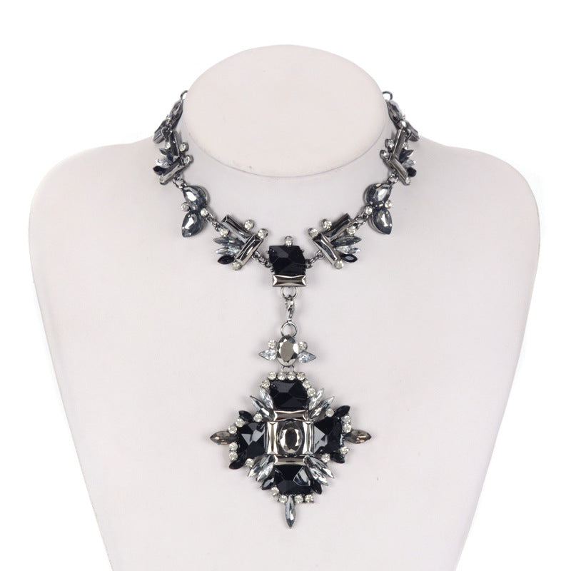 Necklace with black and silver pendant on a mannequin bust against a white background