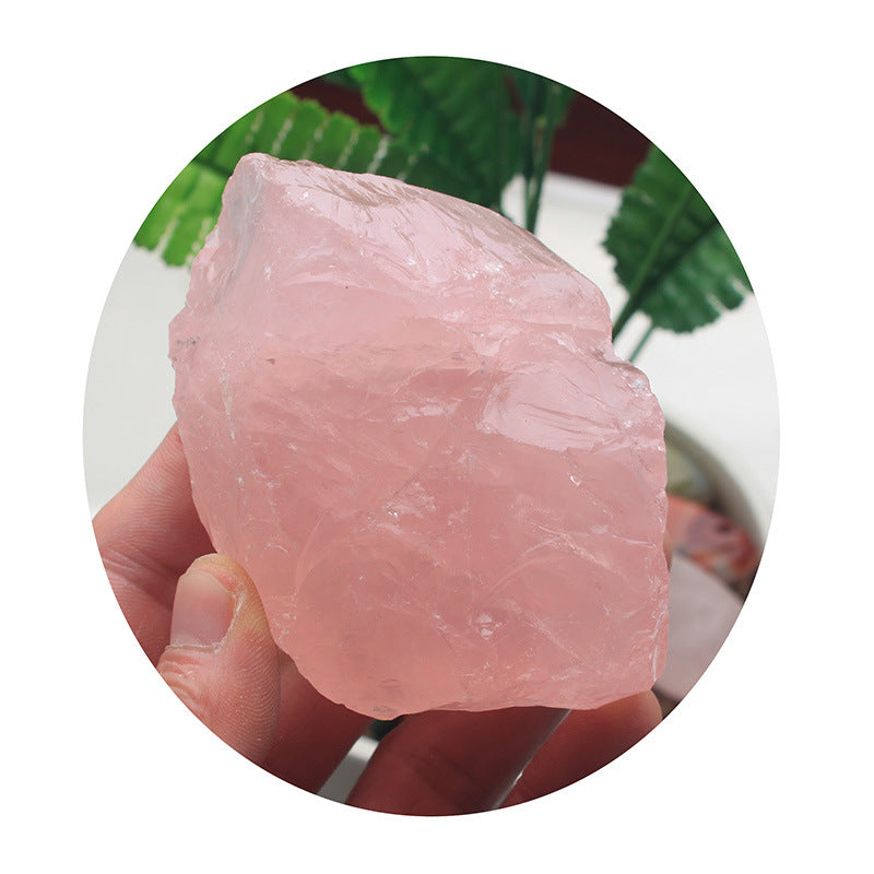 Raw pink meat held on a fork with a blurred green leafy background