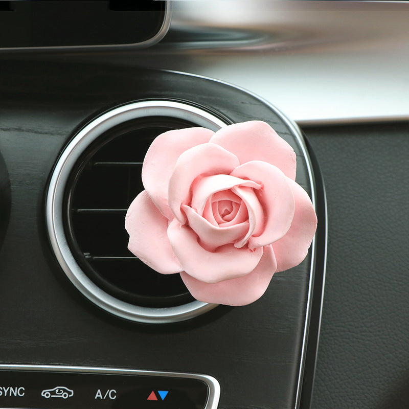 Pink rose-shaped car air freshener on a car dashboard