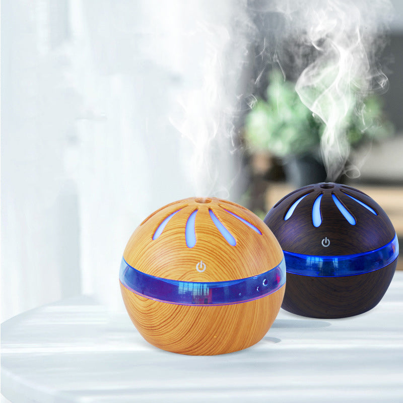 Two spherical humidifiers, one orange and one black, emitting steam on a light background.