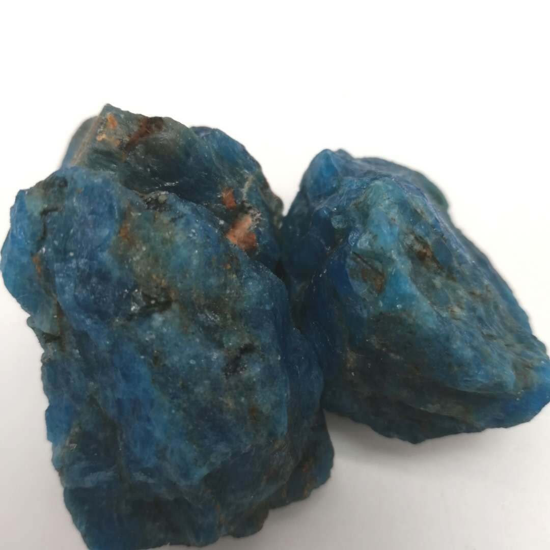 Two blue mineral rocks on a white background