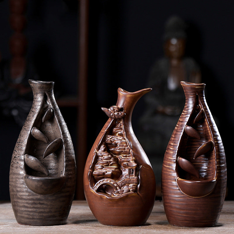 Three decorative vases with intricate designs on a wooden surface.