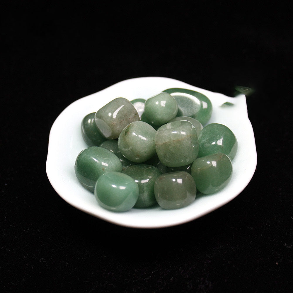 Green stones on a white plate with a black background