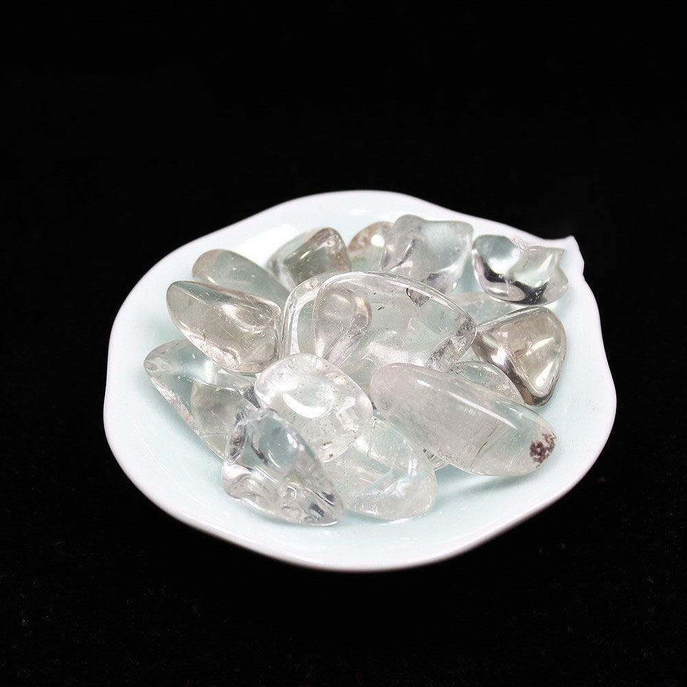 Clear crystal stones on a white plate against a black background