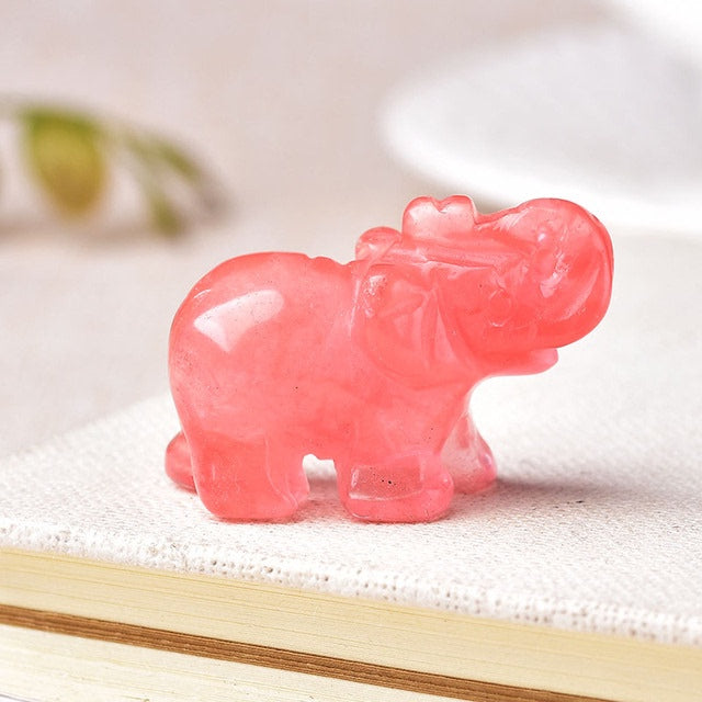 Pink crystal hippo figurine on a white surface with a blurred background