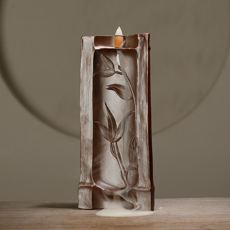 Decorative oil burner with leaf design on a wooden surface