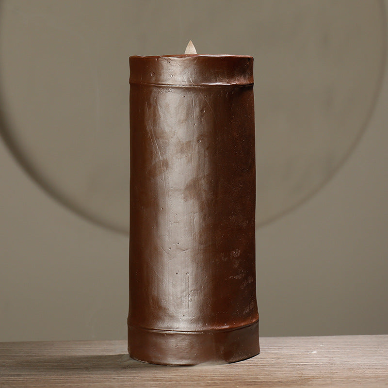 Brown cylindrical incent, on a wooden surface with a neutral background