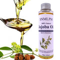 Bottle of SNMLPM Jojoba Oil with a spoonful of oil and jojoba beans on a white background
