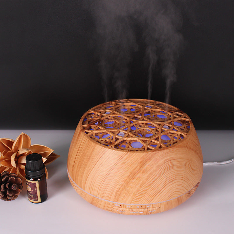 Wooden diffuser emitting steam with a bottle and flowers on a dark background