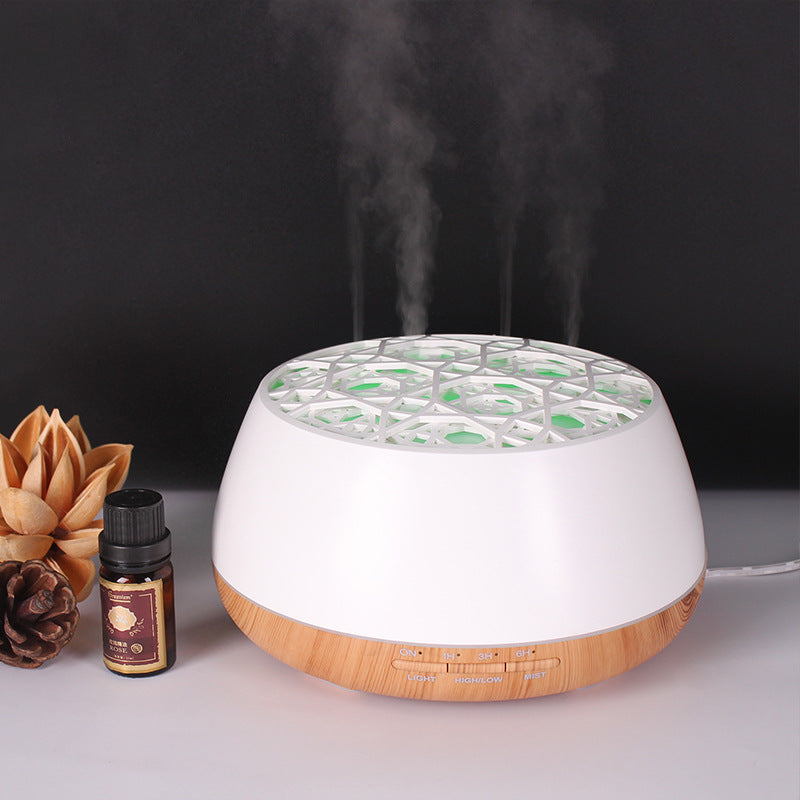 Aromatherapy diffuser with steam and essential oil bottle on a dark background
