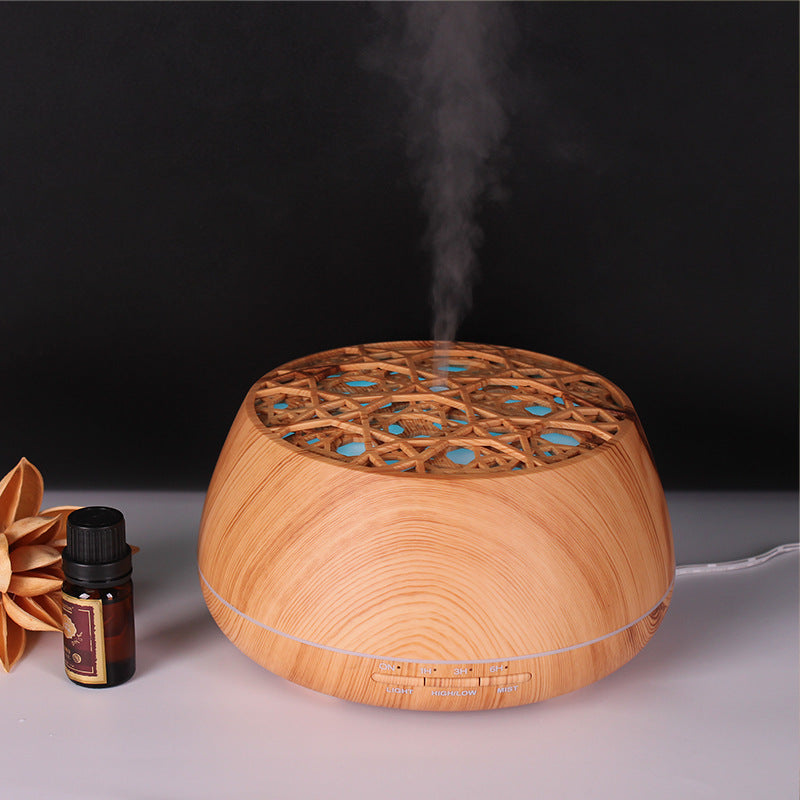 Wooden diffuser with steam and a bottle of essential oil on a dark background