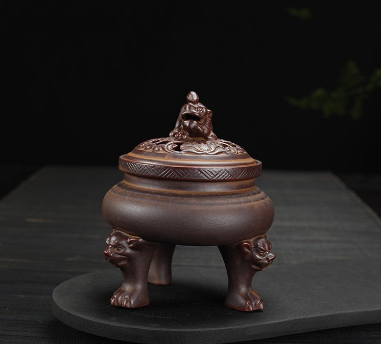Decorative brown pot with lion heads on a dark background