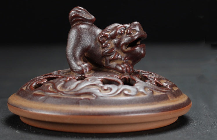Decorative incense burner with a lion design on a dark background