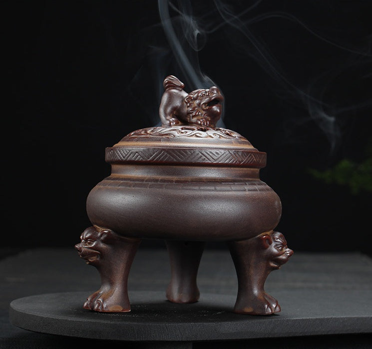 Decorative incense burner with lion design on a dark background