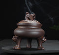 Decorative incense burner with lion design on a dark background