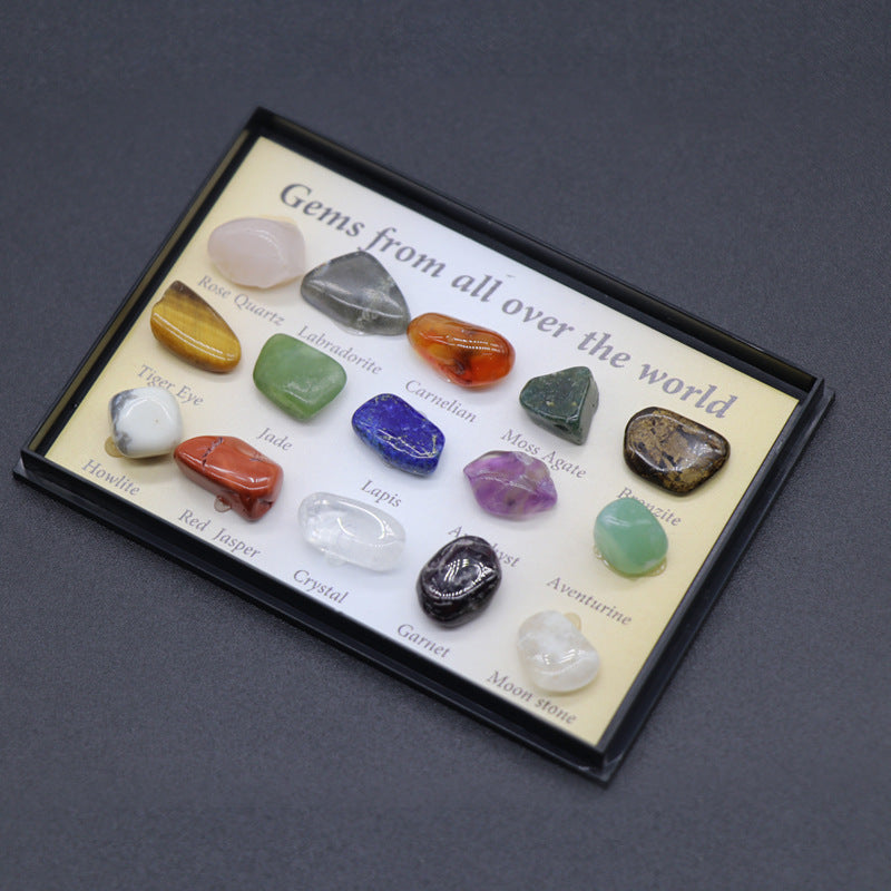 Collection of various gemstones in a display case with labels on a dark background