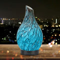 Blue textured diffuser on a wooden surface with a cityscape background