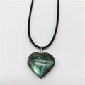 Heart-shaped labradorite pendant on a black cord against a white background