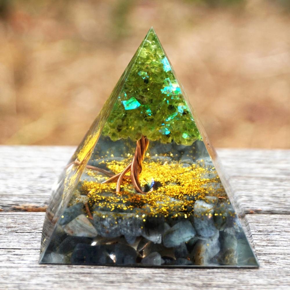 Pyramid-shaped decorative item with a forest scene inside, on a wooden surface.