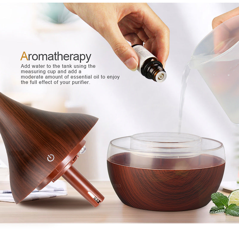 Wooden diffuser with essential oil being added, on a light background