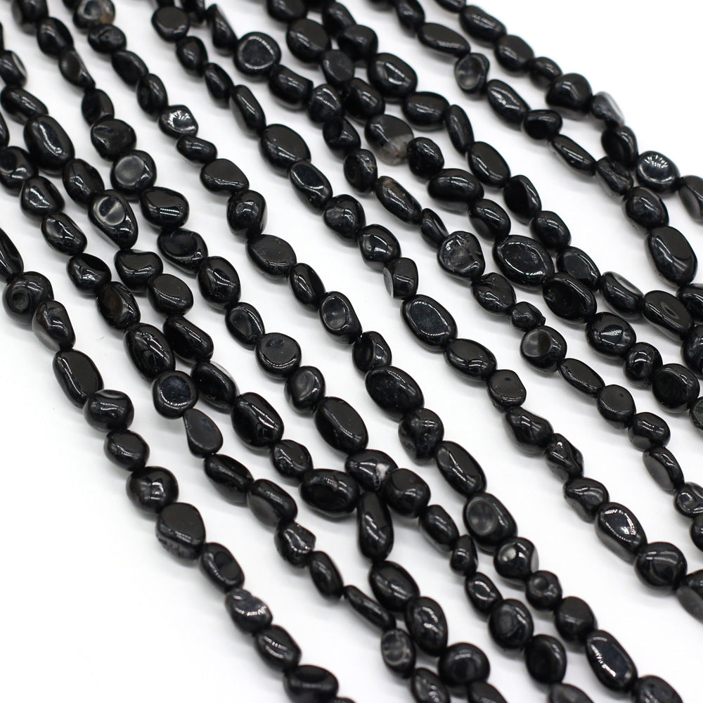Multiple strands of black beads on a white background