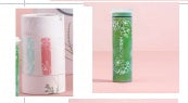 Two green bottles with pink caps on a pink background