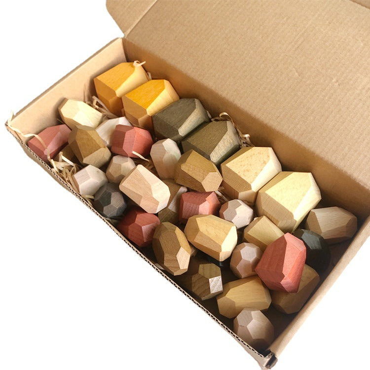 Box of multicolored geometric stone toys on a white background