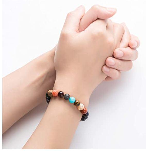 Multicolored beaded bracelet on a wrist with a white background