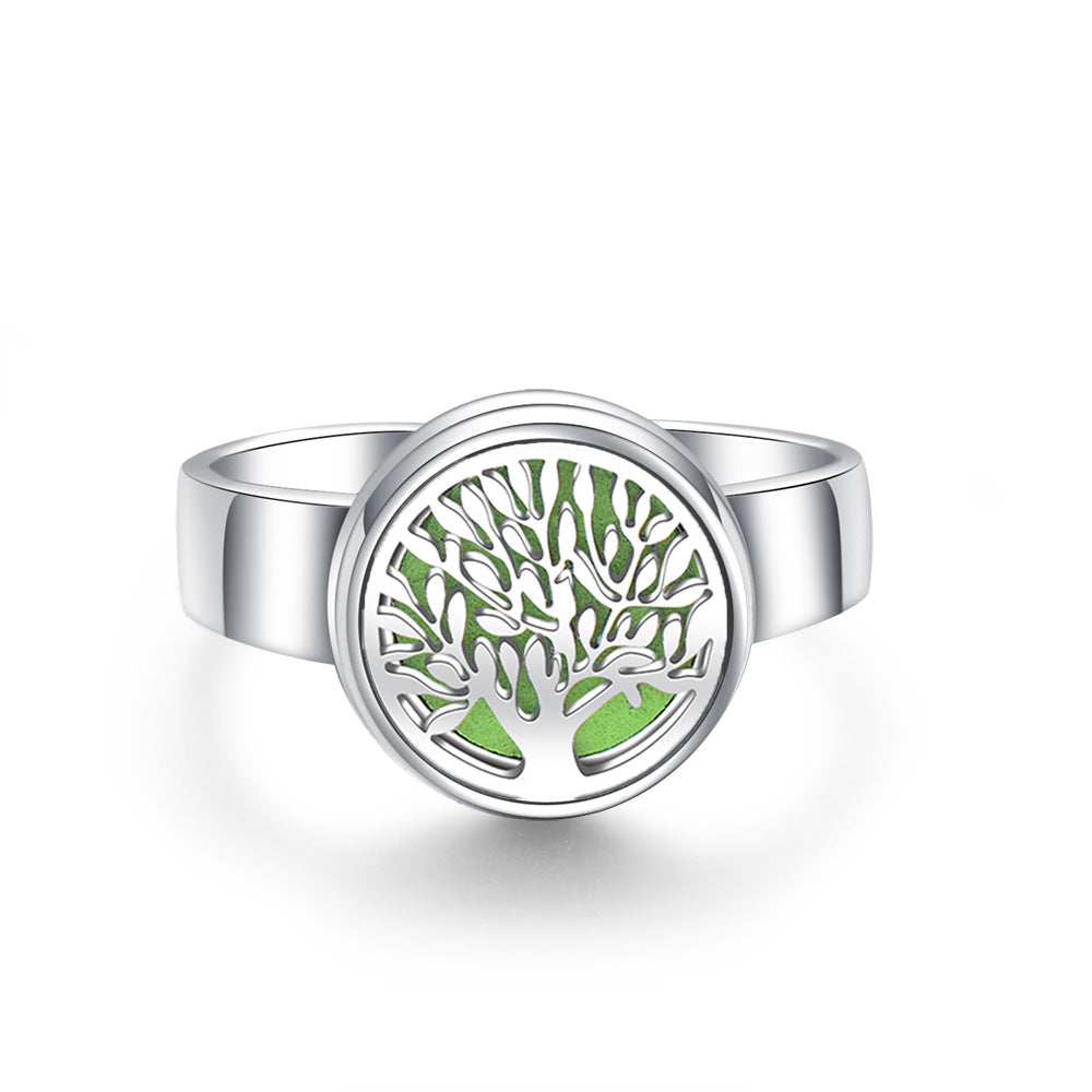 Silver ring with a green tree design on a white background