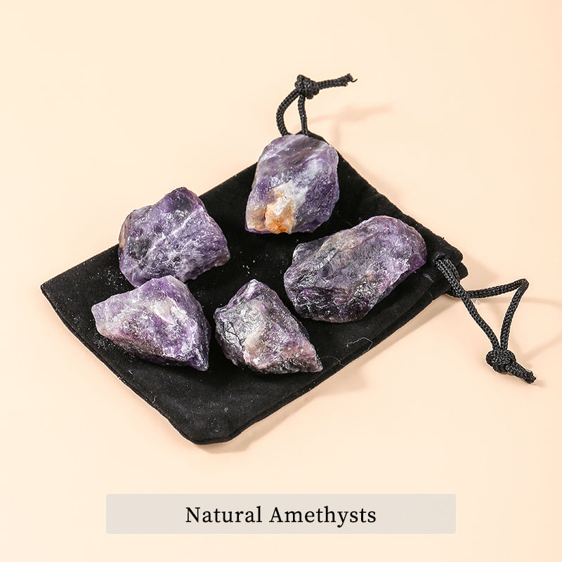 Set of natural amethyst crystals on a black cloth with a beige background