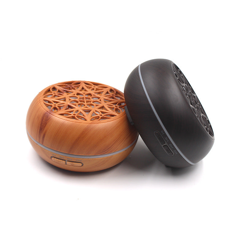 Two round devices, one wooden and one black, on a white background