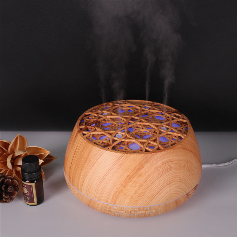 Wooden diffuser emitting steam with a bottle and flower on a dark background
